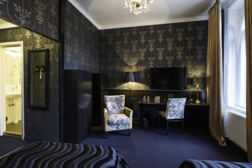 a bedroom with a bed and a desk and a television at Stadshotellet Lidköping in Lidköping