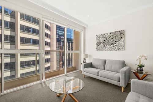 a living room with a couch and a large window at Bond 1218 Self Catering in Sydney