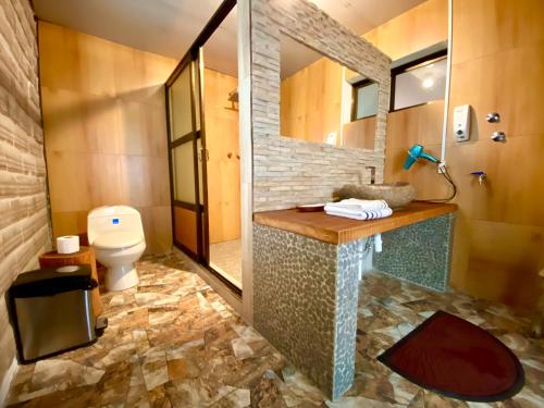 a bathroom with a sink and a toilet and a mirror at Casa de Sal - Salt Hotel in Uyuni