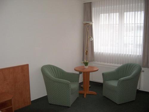 a room with two chairs and a table and a window at Alter Dorfkrug Am Kanal in Wolfsburg