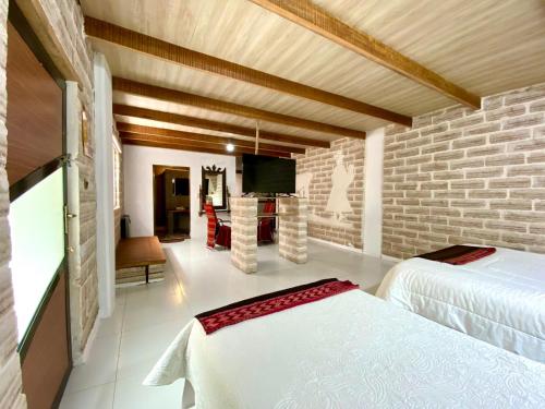 a bedroom with a white bed and a brick wall at Casa de Sal - Salt Hotel in Uyuni