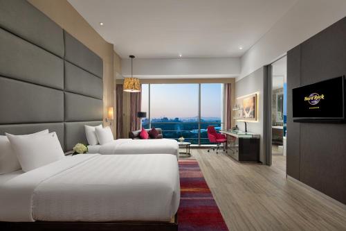 a hotel room with two beds and a desk at Hard Rock Hotel Shenzhen in Shenzhen