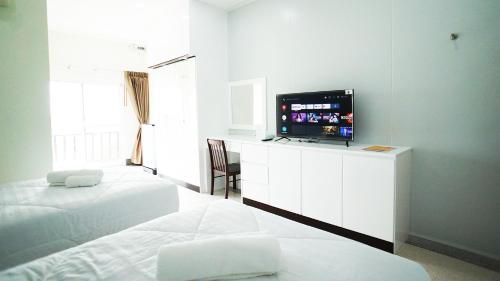a bedroom with two beds and a flat screen tv at PT Grand Hotel in Ban Tha Makham