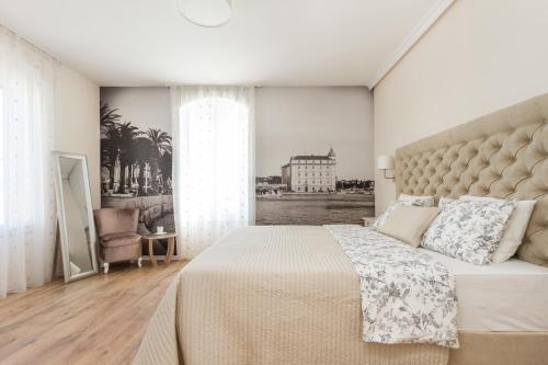 a bedroom with a large bed and a large window at Spalatum Boutique Suites in Split