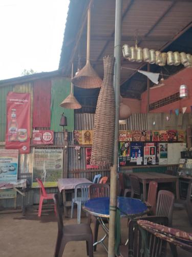 a restaurant with tables and chairs and pendant lights at Jar rai village homestay& Sona trekking tour in Banlung
