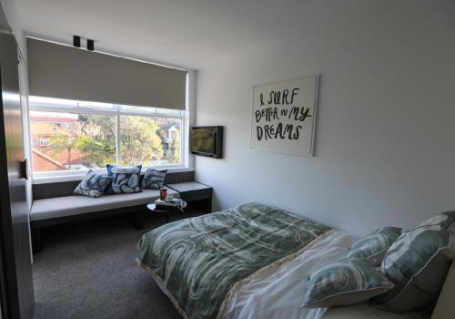 um quarto com uma cama e uma janela em Beach Road Hotel em Sydney