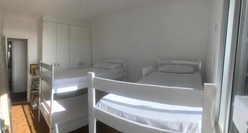 een witte kamer met 2 stapelbedden bij Praia do Futuro Vista Mar in Fortaleza