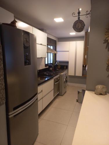a kitchen with a stainless steel refrigerator and a stove at Aptoaconchegantepoa in Porto Alegre