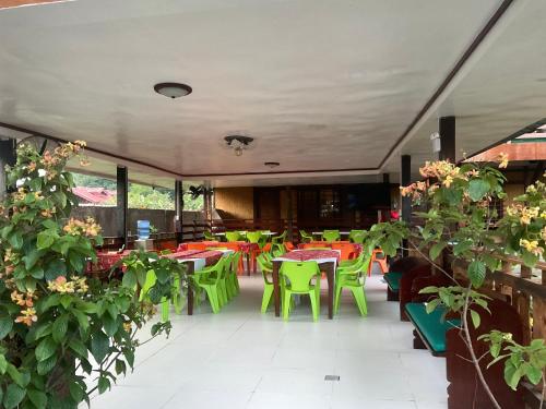 un ristorante con tavoli e sedie colorati e piante di Pinaluyan Guest House a Città di Puerto Princesa