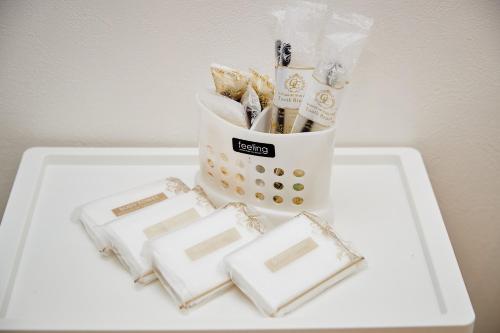 a white table with a container filled with cookies at New Normal Hotel in NAGO ニューノーマルホテルイン名護 in Nago