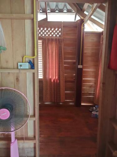 a room with a fan and a room with a window at Relax House in Ko Phayam