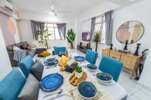 een woonkamer met een tafel en blauwe stoelen bij Kelana Puteri by JustStay 7mins walking to Paradigm Mall in Petaling Jaya