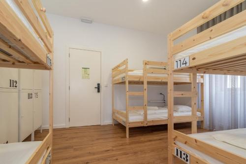 a room with two bunk beds and a door at Dude Beach Hostel in Figueira da Foz