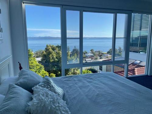 a bedroom with a bed with a view of the ocean at Spectacular water views & entertaining spaces in Corlette