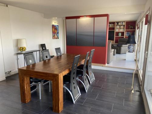 une salle à manger avec une table et des chaises en bois dans l'établissement Appartement panoramique au centre de Moulins avec terrasse, 2 chambres, et équipements modernes - FR-1-489-412, à Moulins