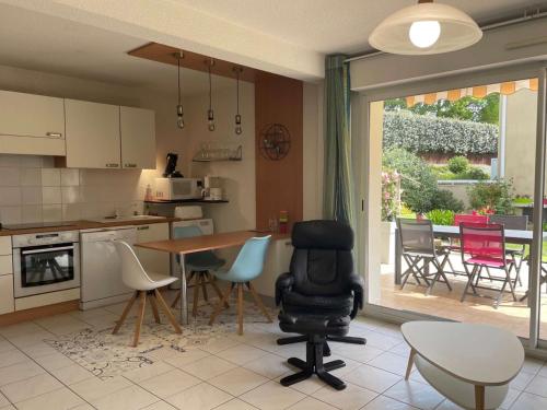 une cuisine avec une table et des chaises ainsi qu'une salle à manger dans l'établissement Appartement 41m² à Capbreton, jardin privatif, proche plages et centre, 4 pers - FR-1-239-872, à Capbreton