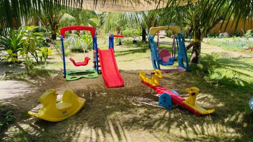 a group of childrens playground equipment in the sand at Footprints Beach Resort in Agpudlos
