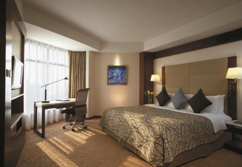 a hotel room with a bed and a desk at Shangri-La Shenzhen - Nearby Luohu Border, Outdoor Swimming Pool in Shenzhen
