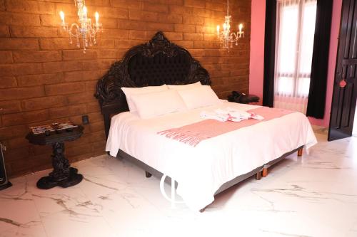 a bedroom with a bed in a brick wall at Casa Rosa Hotel & Spa in San Cristóbal de Las Casas