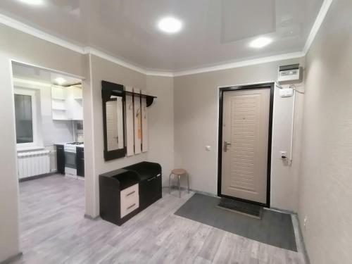 Il comprend un salon avec une porte et une cuisine. dans l'établissement Квартира на Бр Жубановых 283 корпус 1, à Aqtöbe