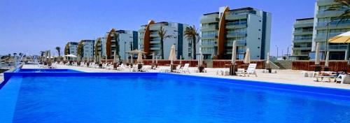 a swimming pool in front of some tall buildings at Nuevo Paracas Apartment in Paracas