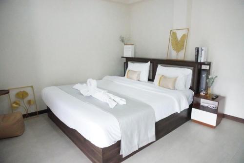 a bedroom with a large bed with white sheets at ATC Residence in Bang Su