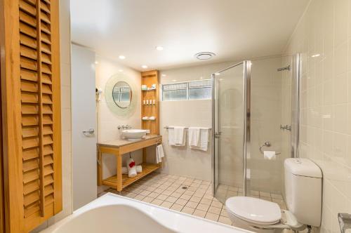 a bathroom with a shower and a toilet and a sink at Seagulls in Townsville