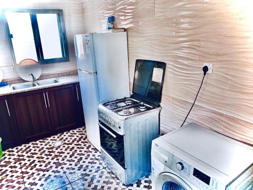 a kitchen with a stove and a refrigerator at Galaxy Apartments in Aqaba