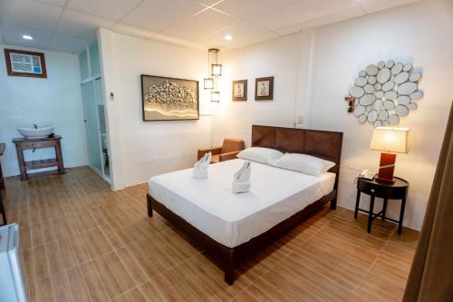 um quarto com uma cama, uma mesa e um candeeiro em MADISON GARDEN AND RESIDENCES em Panglao