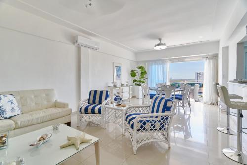 a living room with a couch and a table with chairs at Sunset View 2BR Apartamento Juan Dolio Las Velas in Juan Dolio