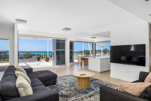 Cote D'Azur Resort في خليج نيلسون: غرفة معيشة مع أريكة وتلفزيون