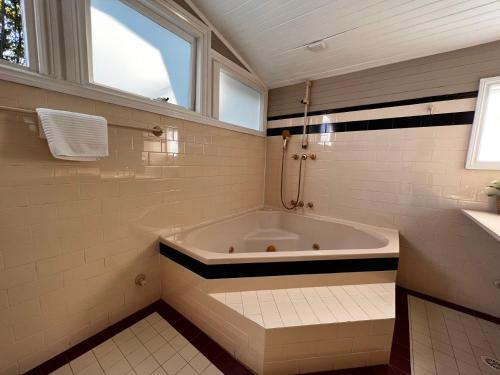 uma casa de banho branca com uma banheira e uma janela em The Boutique Hotel Blue Mountains em Blackheath