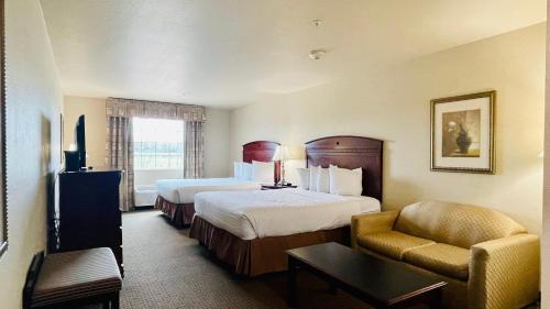 a hotel room with two beds and a chair at Franklin Inn & Suites in Franklin
