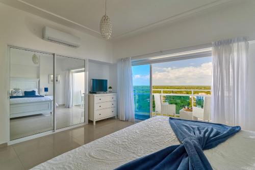 a bedroom with a bed and a view of the ocean at Sunset View 2BR Apartamento Juan Dolio Las Velas in Juan Dolio