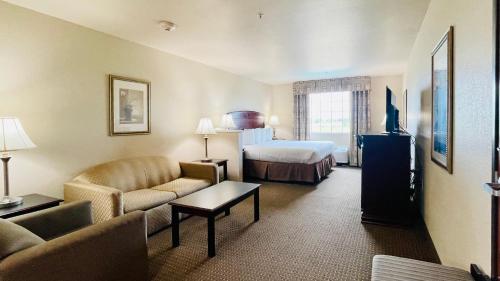 a hotel room with a couch and a bed at Franklin Inn & Suites in Franklin