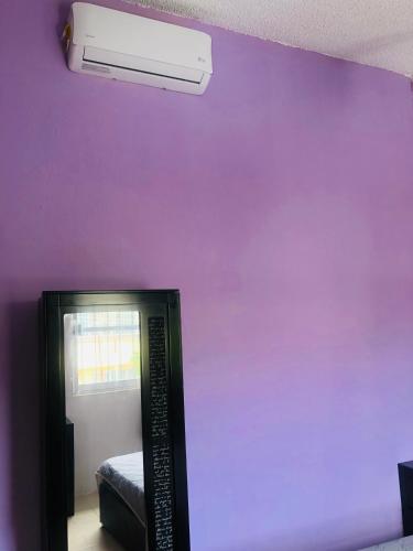 Cette chambre est dotée d'un mur violet et de la climatisation. dans l'établissement Tláloc House, à Tuxtla Gutiérrez