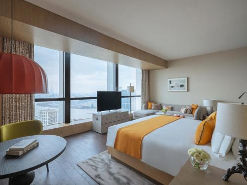 - une chambre avec un grand lit et une grande fenêtre dans l'établissement MGM Shanghai West Bund, à Shanghai