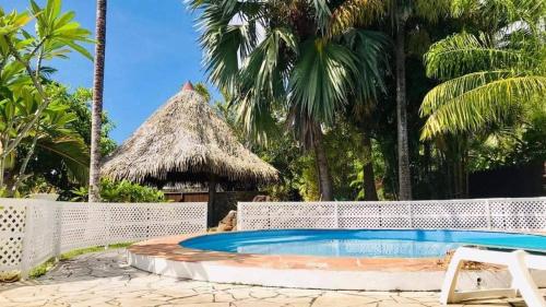 einen Pool vor einem Resort mit Palmen in der Unterkunft MOOREA VILLA KAHAIA in Teavaro