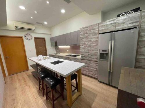 a kitchen with a stainless steel refrigerator and a table at FengJia Pleasure Life 1 in Taichung