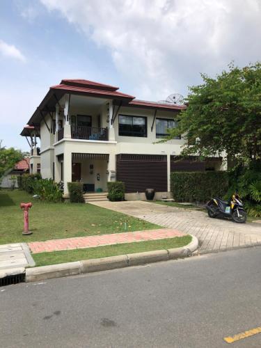 a house with a motorcycle parked in front of it at Laguna Phuket - Superior pool villa in Layan Beach