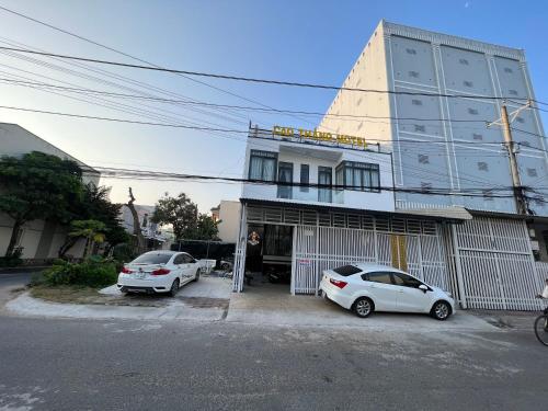 two cars parked in a parking lot in front of a building at Nhà Nghĩ Cao Thắng in Bạc Liêu