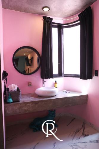 a pink bathroom with a sink and a mirror at Casa Rosa Hotel & Spa in San Cristóbal de Las Casas