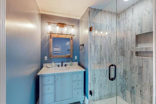 a blue bathroom with a sink and a shower at Sun Sprinkles in Kure Beach