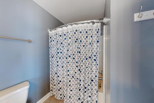 a bathroom with a shower with a shower curtain at Sun Sprinkles in Kure Beach