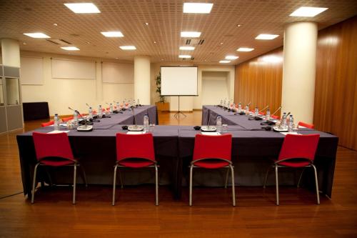 a long table in a room with red chairs at MS Aparthotel in Linda-a-Velha