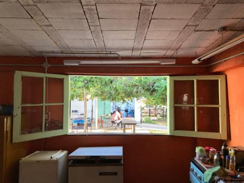 a window in a room with a person sitting at a table at Club de Veraneantes Tulumba Hostel y suites in Villa Tulumba