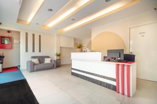 an office lobby with a reception desk and a couch at Swing & Pillows - PJ SS2 in Petaling Jaya