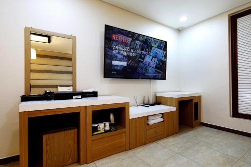 a bathroom with a sink and a tv on the wall at White Tourist Hotel in Jeonju