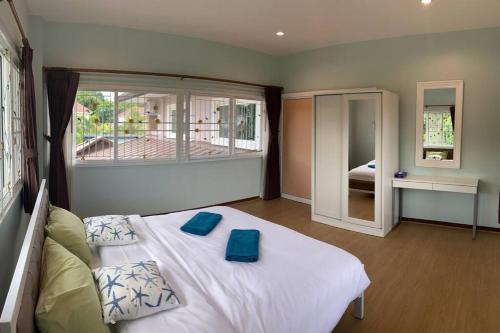 1 dormitorio con 1 cama con 2 almohadas azules en Let's Chill Pool Villa Pattaya Najomtien42 and Sattahip, en Ban Tao Than