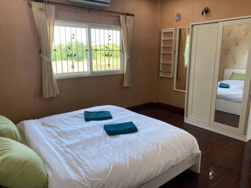 a bedroom with a bed with two towels on it at Let's Chill Pool Villa Pattaya Najomtien42 and Sattahip in Ban Tao Than